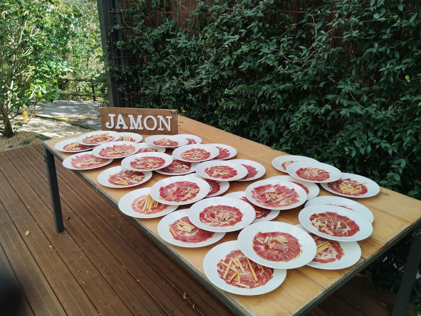 Mesa de platos de jamón emplatados en una boda