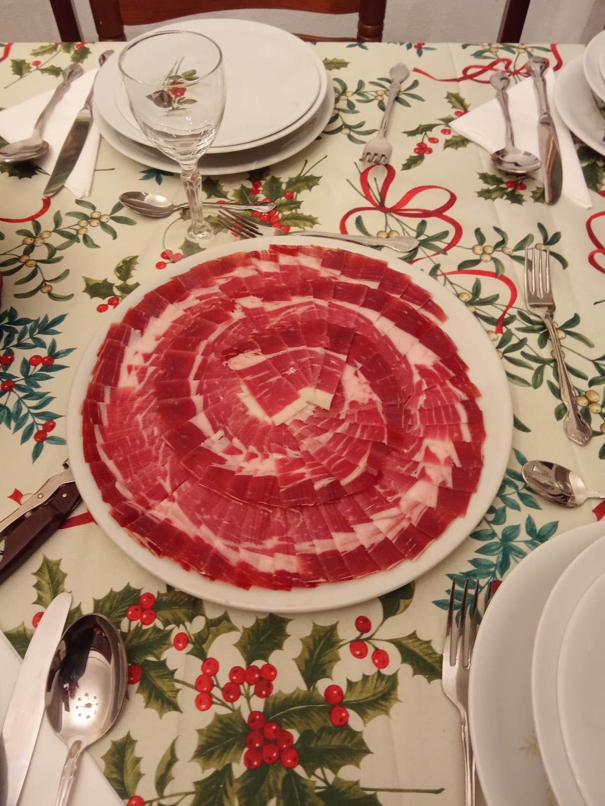 Plato de jamón en rosetón en una mesa de Navidad